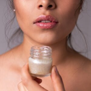 woman holding white plastic bottle