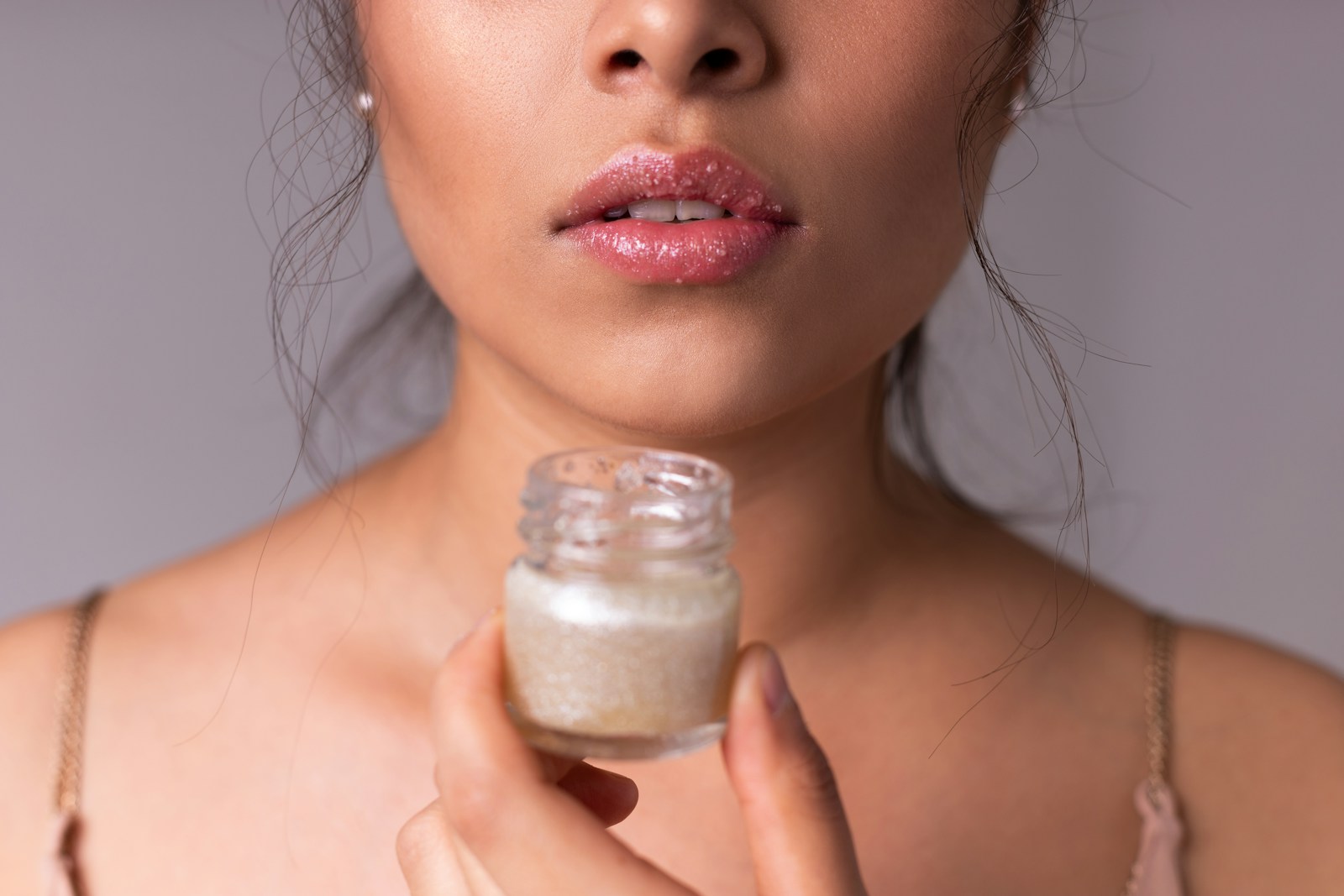 woman holding white plastic bottle